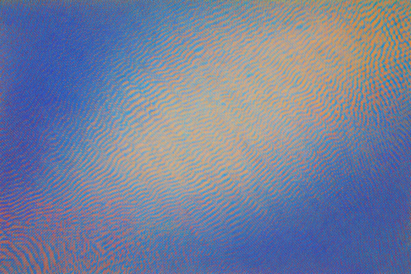Textura abstracta difusa con un resplandor anaranjado central rodeado de tonos azules, como niebla.