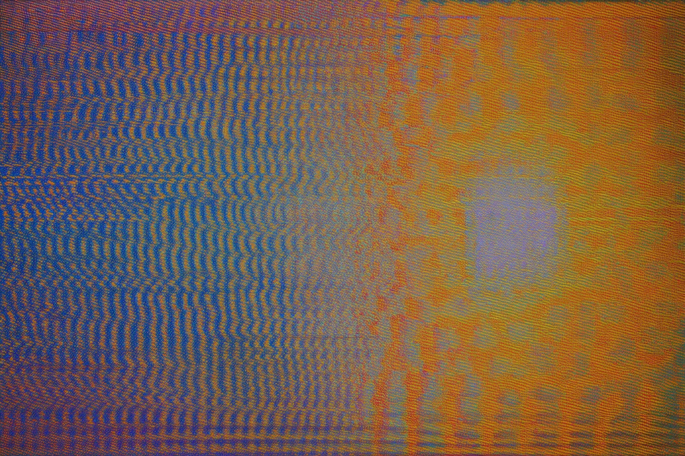 Textura abstracta dividida en dos mitades verticales, azul y morada a la izquierda, naranja a la derecha, con un círculo de luz pálida en el centro.