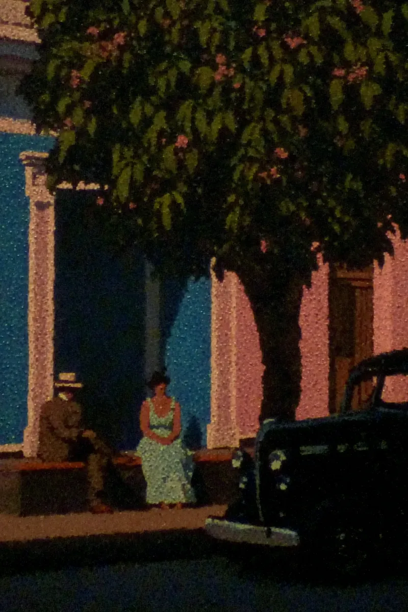 Pintura de una calle con casas coloniales azules y rosadas, un árbol con flores rosadas, dos personas sentadas en una banca y un automóvil antiguo negro estacionado cerca, con textura pictórica granulada.