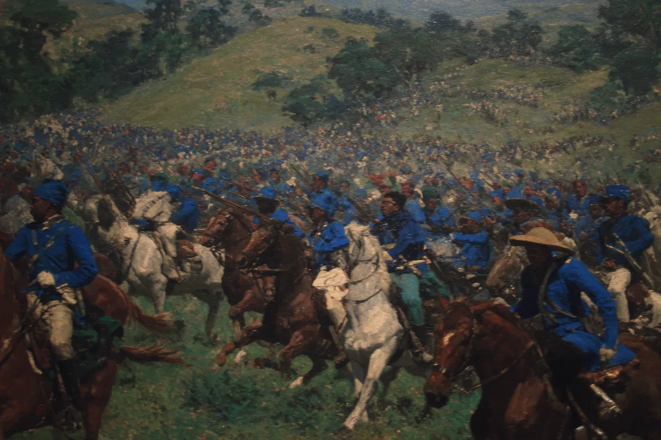 Pintura de cientos de jinetes uniformados desplegados sobre una colina extensa, con soldados de uniforme azul avanzando a caballo en primer plano, un valle verde y cielo despejado al fondo.